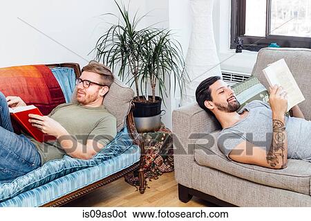 Stock Photograph - Male couple reading at home. Fotosearch