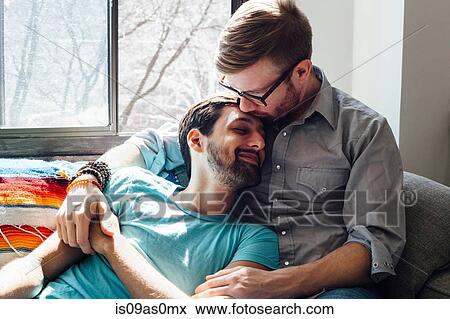 Male couple relaxing on sofa together View Large Photo Image Stock Photo - Male couple relaxing on sofa together. Fotosearch