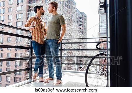 Male couple standing on balcony, face to face View Large Photo Image Stock Image - Male couple standing on balcony, face to face. Fotosearch