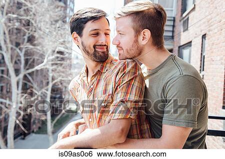 Male couple standing on balcony, embracing, face to face View Large Photo Image Stock Photograph - Male couple standing on balcony, embracing, face to face. Fotosearch
