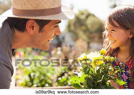 Mid adult man and daughter with yellow flower plant in community garden View Large Photo Image Stock Photography - Mid adult man and daughter with yellow flower plant in community garden. Fotosearch