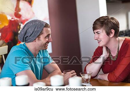 Mid adult man and young woman chatting and drinking in recreational bar View Large Photo Image Stock Photograph - Mid adult man and young woman chatting and drinking in recreational bar. Fotosearch