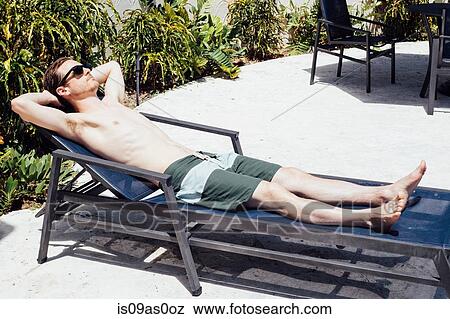 Mid adult man sunbathing on lounger, Miami Beach, Florida, USA View Large Photo Image Stock Photo - Mid adult man sunbathing on lounger, Miami Beach, Florida, USA. Fotosearch
