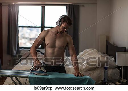 Mid adult man wearing boxer shorts listening to headphones whilst ironing View Large Photo Image Stock Photography - Mid adult man wearing boxer shorts listening to headphones whilst ironing. Fotosearch