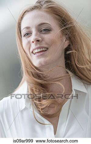 Portrait of beautiful young woman with long red windswept hair View Large Photo Image Stock Photo - Portrait of beautiful young woman with long red windswept hair. Fotosearch