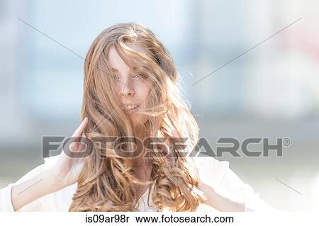 Stock Photography - Portrait of beautiful young woman with long red windswept hair. Fotosearch