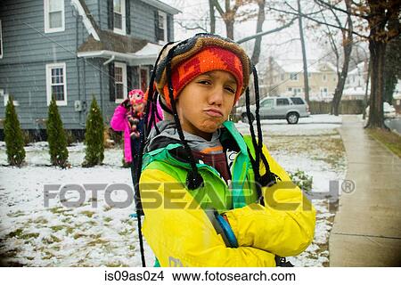 Picture - Portrait of boy wearing knit hat with plaits in snowy garden. Fotosearch