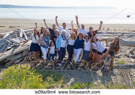 Picture - Portrait of four generation family waving from beach. Fotosearch