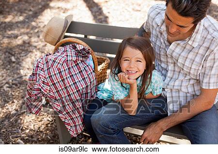 Portrait of girl in community garden sitting on bench with father View Large Photo Image Stock Image - Portrait of girl in community garden sitting on bench with father. Fotosearch