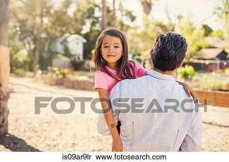 Portrait of girl in community garden carried by father View Large Photo Image Stock Photography - Portrait of girl in community garden carried by father. Fotosearch