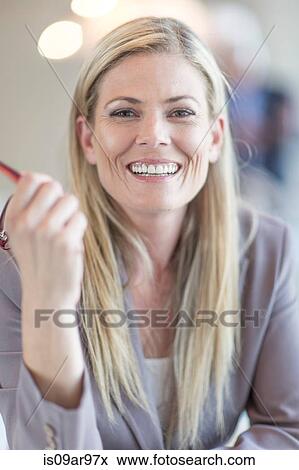 Portrait of mid adult businesswoman holding spectacles View Large Photo Image Stock Photo - Portrait of mid adult businesswoman holding spectacles. Fotosearch