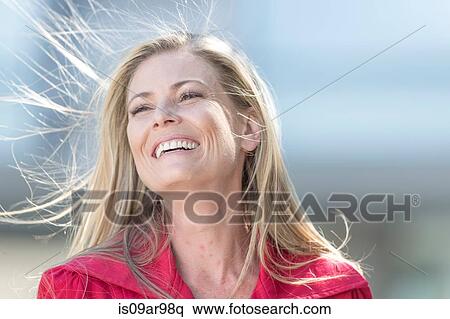 Portrait of smiling mid adult woman with long blond flyaway hair View Large Photo Image Stock Photography - Portrait of smiling mid adult woman with long blond flyaway hair. Fotosearch