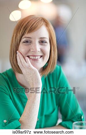 Stock Photo - Portrait of smiling young businesswoman with red hair. Fotosearch
