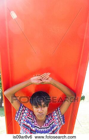 Portrait of young man behind orange playground slide View Large Photo Image Stock Photograph - Portrait of young man behind orange playground slide. Fotosearch