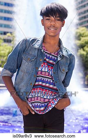 Stock Image - Portrait of young man in front of city fountain. Fotosearch
