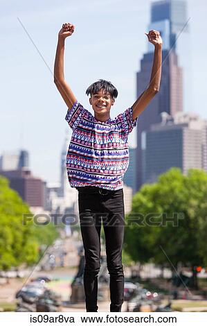 Portrait of young man with arms raised in front of city skyline, Philadelphia, Pennsylvania, USA View Large Photo Image Stock Image - Portrait of young man with arms raised in front of city skyline, Philadelphia, Pennsylvania, USA. Fotosearch