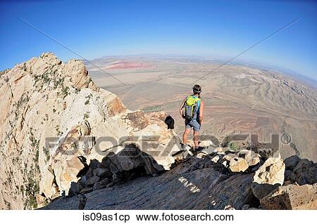 Rear view of young female rock climber looking out from top of Mount Wilson, Nevada, USA View Large Photo Image Stock Photography - Rear view of young female rock climber looking out from top of Mount Wilson, Nevada, USA. Fotosearch