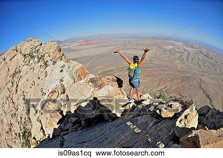 Rear view of young female rock climber with arms open on top of Mount Wilson, Nevada, USA View Large Photo Image Stock Photography - Rear view of young female rock climber with arms open on top of Mount Wilson, Nevada, USA. Fotosearch