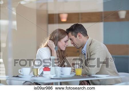 Stock Photograph - Romantic business couple head to head at hotel breakfast table. Fotosearch