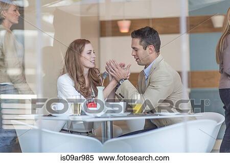 Romantic business couple holding hands at hotel breakfast table View Large Photo Image Stock Photography - Romantic business couple holding hands at hotel breakfast table. Fotosearch