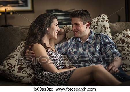Romantic young couple reclining on living room sofa View Large Photo Image Stock Image - Romantic young couple reclining on living room sofa. Fotosearch