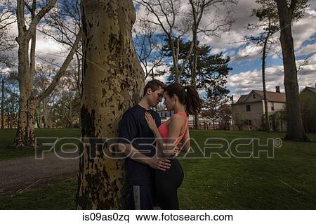 Romantic young sporty couple embracing in park at dusk View Large Photo Image Stock Photography - Romantic young sporty couple embracing in park at dusk. Fotosearch