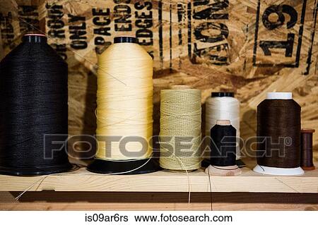 Row of thread bobbins on workshop shelf View Large Photo Image Stock Photograph - Row of thread bobbins on workshop shelf. Fotosearch