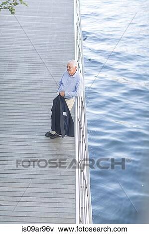 Senior businessman leaning against hotel terrace railings View Large Photo Image Stock Photo - Senior businessman leaning against hotel terrace railings. Fotosearch