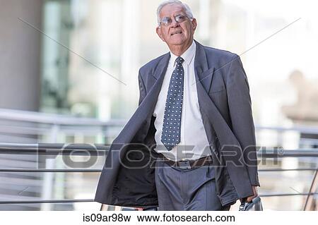 Senior businessman leaving hotel looking upward View Large Photo Image Stock Photo - Senior businessman leaving hotel looking upward. Fotosearch