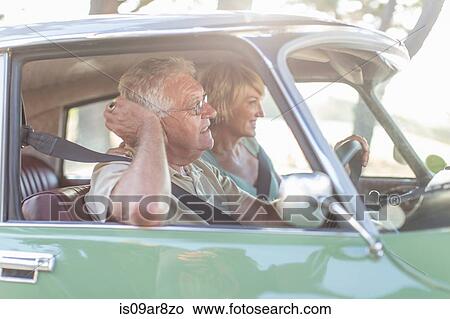 Picture - Senior man and mature woman in car together, smiling. Fotosearch
