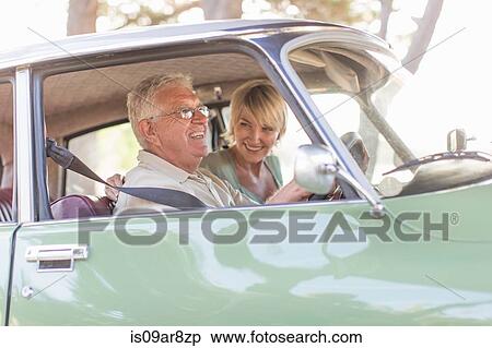 Stock Photography - Senior man and mature woman in car together, smiling. Fotosearch