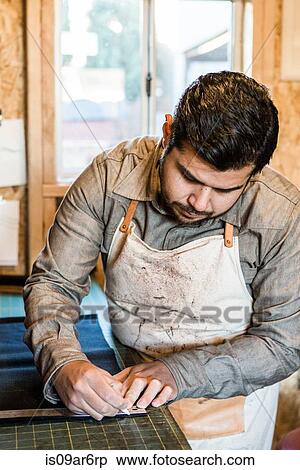 Tailor marking fabric with chalk on workshop bench View Large Photo Image Stock Photography - Tailor marking fabric with chalk on workshop bench. Fotosearch