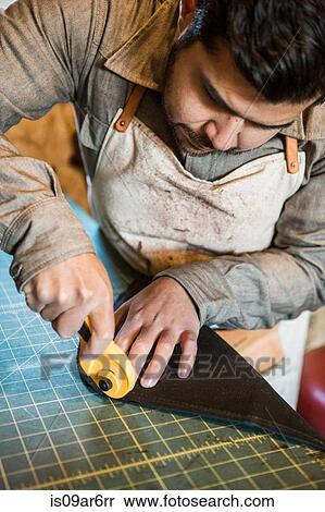 Tailor using rotary cutter on fabric on workshop bench View Large Photo Image Stock Photography - Tailor using rotary cutter on fabric on workshop bench. Fotosearch