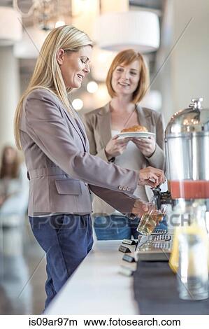 Picture - Two businesswomen getting breakfast in hotel restaurant. Fotosearch
