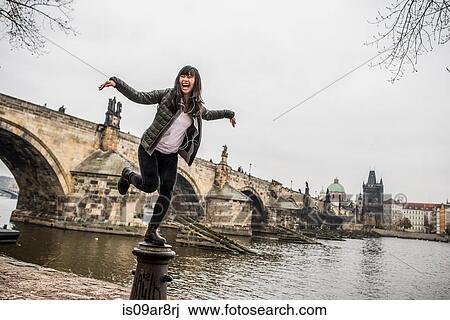 Woman balancing on bollard in front of Charles Bridge, Prague View Large Photo Image Stock Image - Woman balancing on bollard in front of Charles Bridge, Prague. Fotosearch