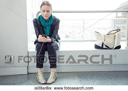Woman listening to music on smartphone View Large Photo Image Stock Photo - Woman listening to music on smartphone. Fotosearch