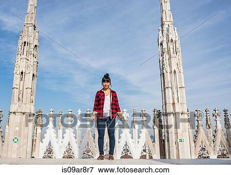 Stock Photo - Woman standing on roof of Duomo Cathedral, Milan, Italy. Fotosearch