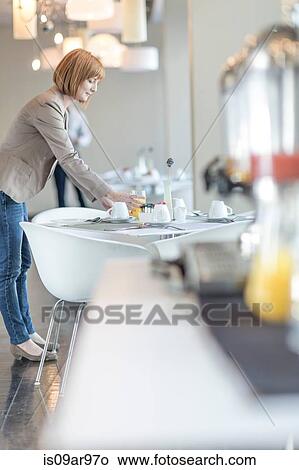 Young businesswoman placing fruit juice on table in hotel restaurant View Large Photo Image Picture - Young businesswoman placing fruit juice on table in hotel restaurant. Fotosearch