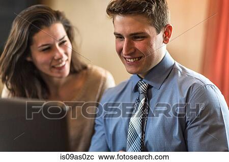 Young couple browsing laptop at home View Large Photo Image Stock Image - Young couple browsing laptop at home. Fotosearch
