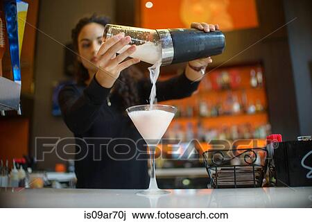 Young female bartender pouring cocktail from shaker in cocktail bar View Large Photo Image Stock Image - Young female bartender pouring cocktail from shaker in cocktail bar. Fotosearch