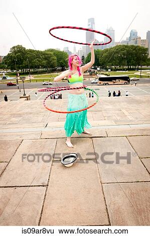 Stock Photograph - Young female performer hoola hooping in park, Philadelphia, Pennsylvania, USA. Fotosearch
