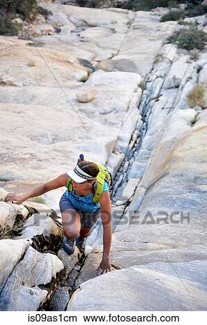 Young female rock climber climbing up crevice, Mount Wilson, Nevada, USA View Large Photo Image Picture - Young female rock climber climbing up crevice, Mount Wilson, Nevada, USA. Fotosearch