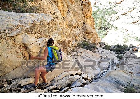 Picture - Young female rock climber pulling herself up steep crevice, Mount Wilson, Nevada, USA. Fotosearch