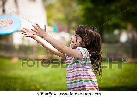 Young girl throwing frisbee in garden View Large Photo Image Picture - Young girl throwing frisbee in garden. Fotosearch