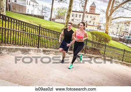 Young male and female runners running up stairway in park View Large Photo Image Stock Image - Young male and female runners running up stairway in park. Fotosearch