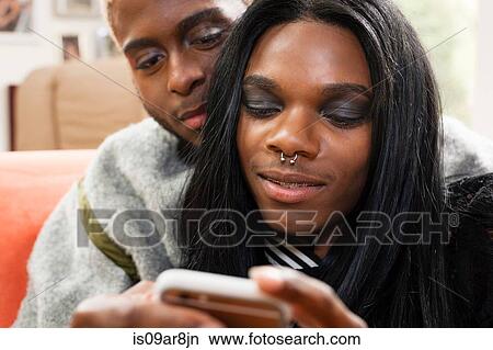 Picture - Young male couple looking at smartphone together. Fotosearch