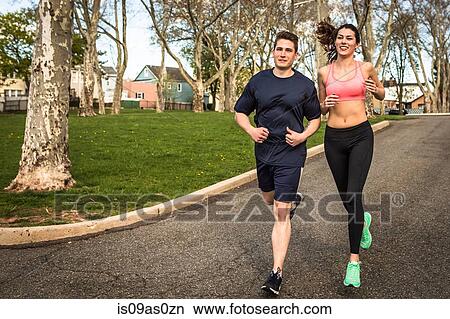 Young man and woman running in park View Large Photo Image Picture - Young man and woman running in park. Fotosearch