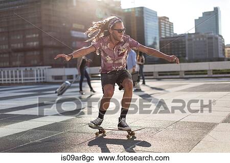 Young man balancing on skateboard View Large Photo Image Stock Image - Young man balancing on skateboard. Fotosearch