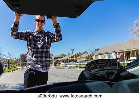Young man closing car boot, Upland, California, USA View Large Photo Image Stock Photograph - Young man closing car boot, Upland, California, USA. Fotosearch