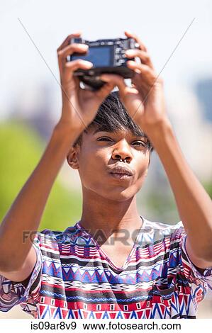 Stock Photo - Young man with nose piercing posing for a selfie. Fotosearch